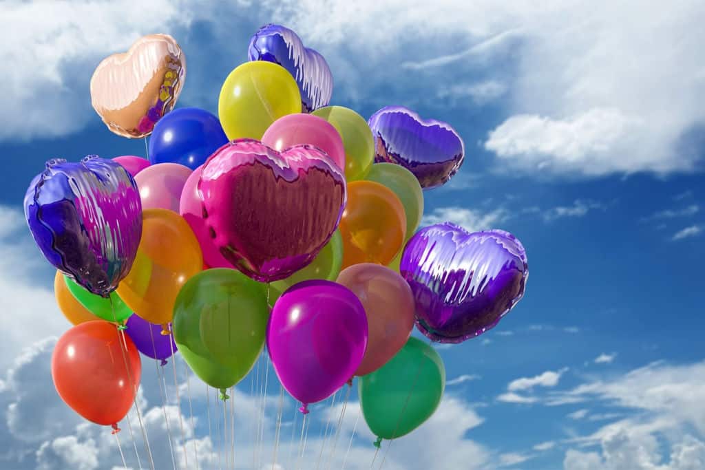 colorful helium balloons in blue sky