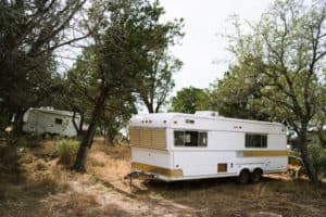 parked rv trailer near green trees