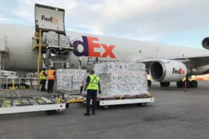 FedEx workers loading packages into airplane