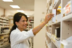 Pharmacist selecting a drug from pharmacy inventory