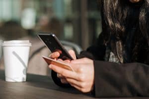 Girl using debit card on the phone outside